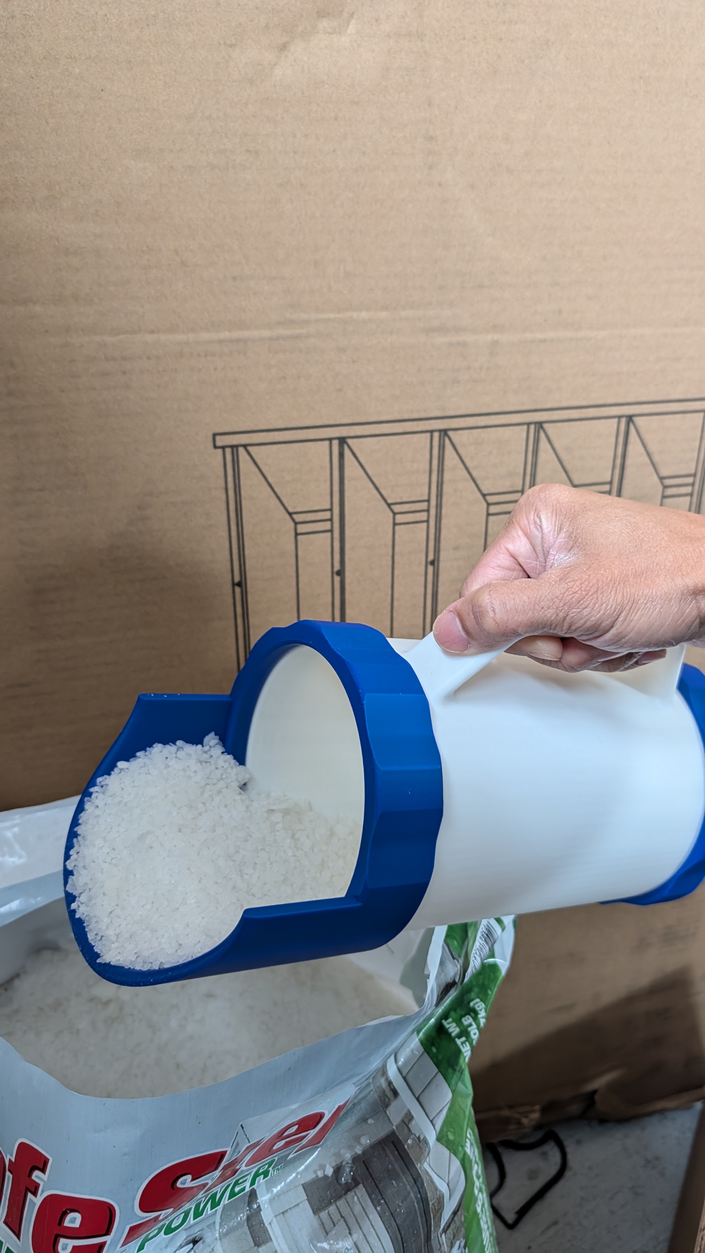 Scoop attached to shaker in use scooping ice melt